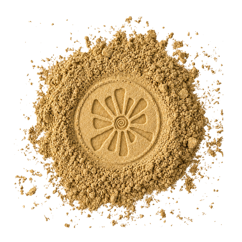 A mound of golden ubtan powder with a sun motif pressed into its centre.